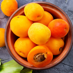 A Bowl of Apricots and Celery on a Table